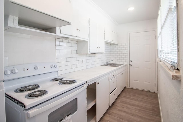 kitchen featuring sink, white electric range, white cabinets, decorative backsplash, and light wood-type flooring