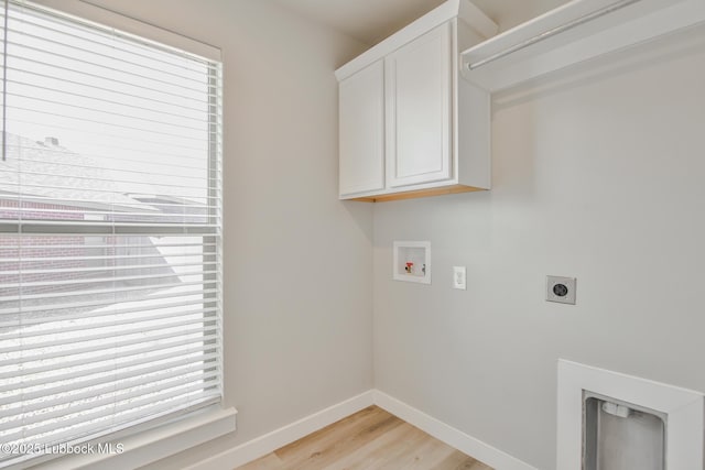 2933 Abbeville Ave, Wolfforth, TX 79382 - washroom with washer hookup, cabinet space, hookup for an electric dryer, light wood finished floors, and healthy amount of natural light