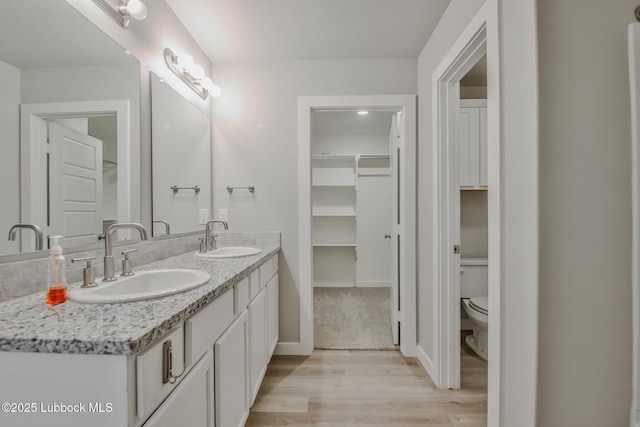 2933 Abbeville Ave, Wolfforth, TX 79382 - full bathroom with wood finished floors, double vanity, and a walk in closet