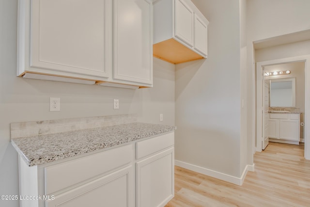 2933 Abbeville Ave, Wolfforth, TX 79382 - kitchen featuring light wood-style floors, light stone counters, and white cabinets