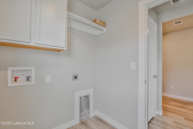 2933 Abbeville Ave, Wolfforth, TX 79382 - laundry area featuring washer hookup, hookup for an electric dryer, light wood-style floors, and cabinet space