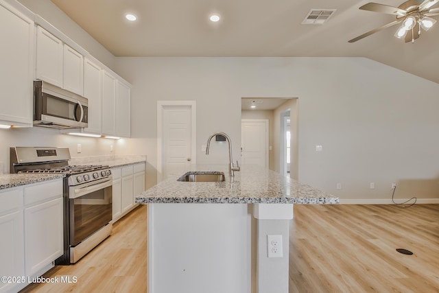 2933 Abbeville Ave, Wolfforth, TX 79382 - kitchen featuring appliances with stainless steel finishes, light wood-style floors, light stone counters, white cabinets, and recessed lighting