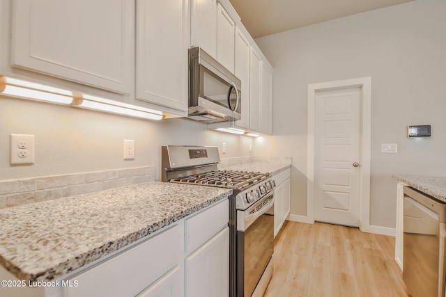 2933 Abbeville Ave, Wolfforth, TX 79382 - kitchen with appliances with stainless steel finishes, light wood-type flooring, white cabinets, and light stone countertops