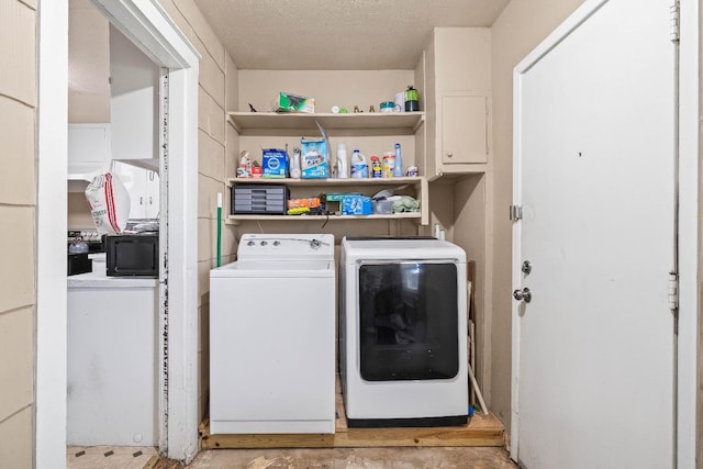 laundry room with a textured ceiling and independent washer and dryer