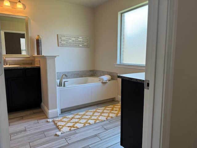 bathroom with vanity and a tub to relax in