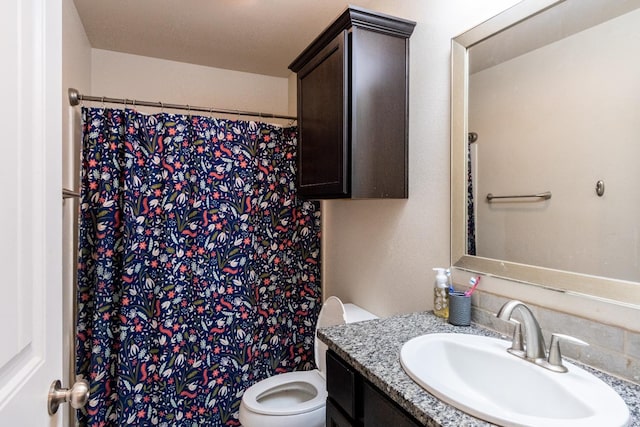 bathroom featuring vanity, curtained shower, and toilet