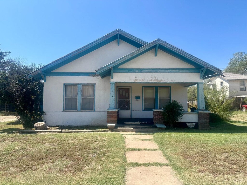 412 S Main St, Floydada, TX 79235 - view of front of house featuring a front yard and a porch