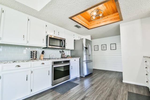 kitchen with white cabinetry, light stone counters, dark hardwood / wood-style flooring, and stainless steel appliances