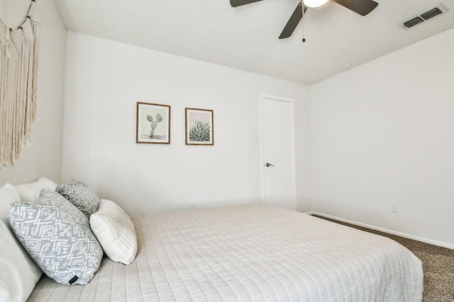 bedroom with ceiling fan, carpet flooring, and a textured ceiling