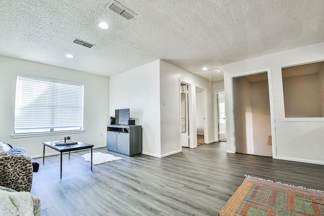 living room with wood-type flooring and a textured ceiling