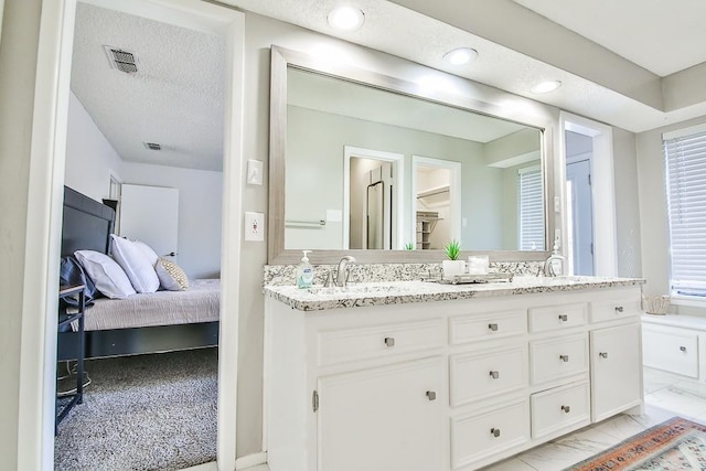 bathroom with vanity and a textured ceiling