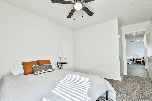 bedroom with ceiling fan, carpet flooring, and a textured ceiling