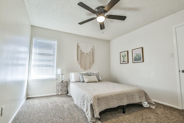 carpeted bedroom featuring ceiling fan and a textured ceiling