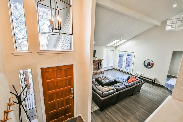 entrance foyer featuring hardwood / wood-style flooring, high vaulted ceiling, a notable chandelier, a fireplace, and beamed ceiling