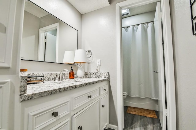 bathroom with hardwood / wood-style flooring, vanity, and shower / bath combination with curtain