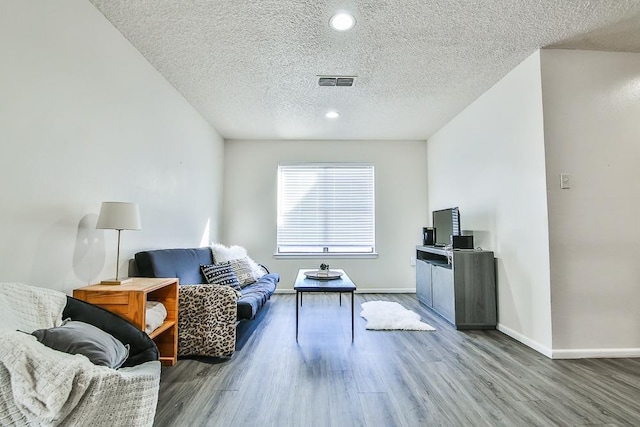 sitting room with hardwood / wood-style floors and a textured ceiling