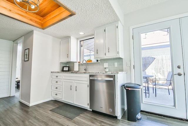 kitchen with dishwasher, dark hardwood / wood-style flooring, white cabinets, and backsplash