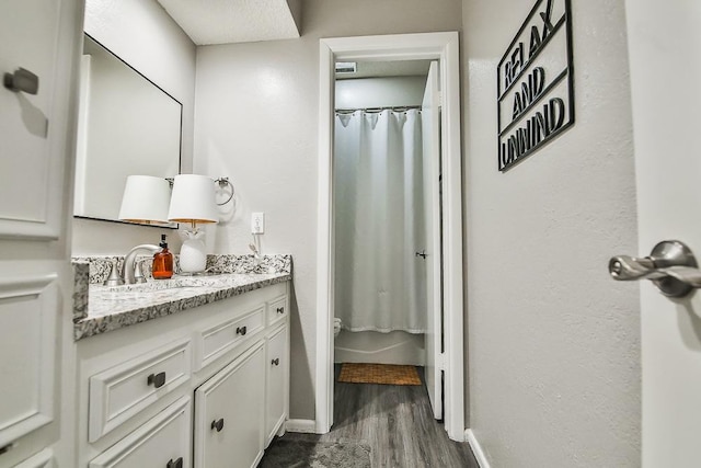 bathroom with vanity, curtained shower, wood-type flooring, and toilet