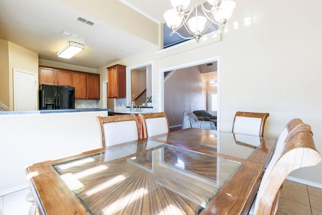 dining space featuring light tile patterned flooring and a chandelier