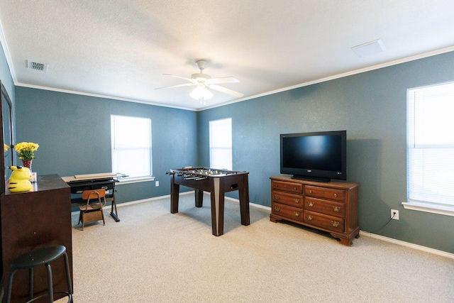 interior space with ornamental molding, light colored carpet, and ceiling fan