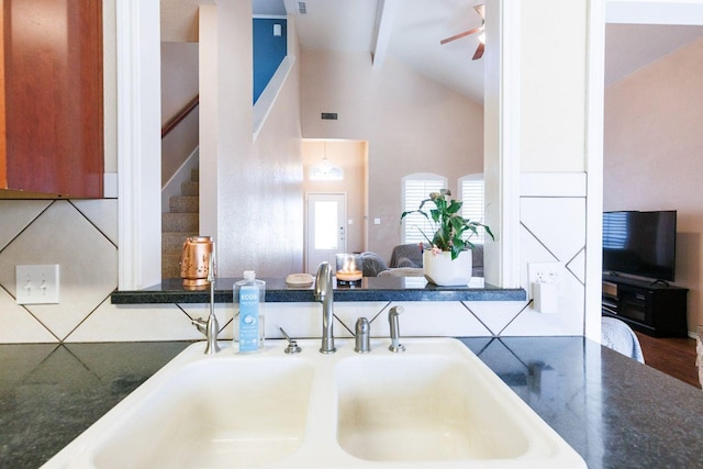 kitchen featuring ceiling fan, sink, and vaulted ceiling with beams