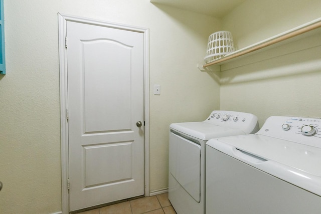 clothes washing area with light tile patterned flooring and independent washer and dryer