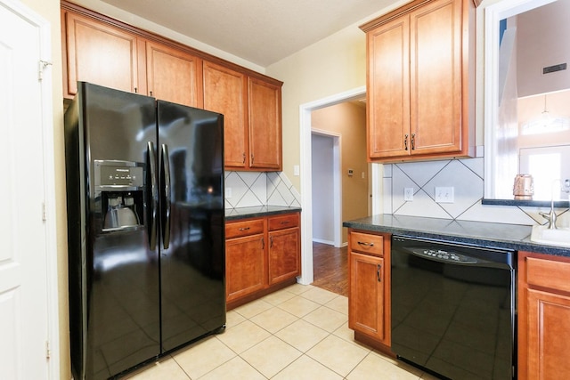 kitchen with light tile patterned flooring, sink, backsplash, and black appliances