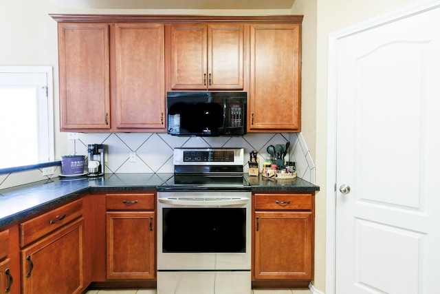 kitchen featuring electric range, decorative backsplash, and light tile patterned flooring