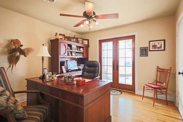 home office featuring french doors, ceiling fan, and light wood-type flooring