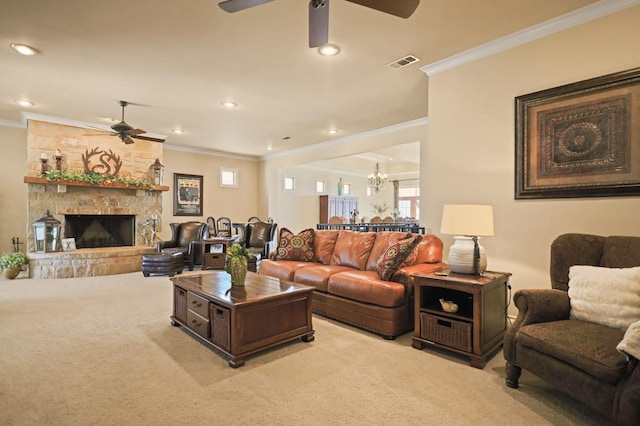 living room with crown molding, ceiling fan with notable chandelier, light colored carpet, and a stone fireplace