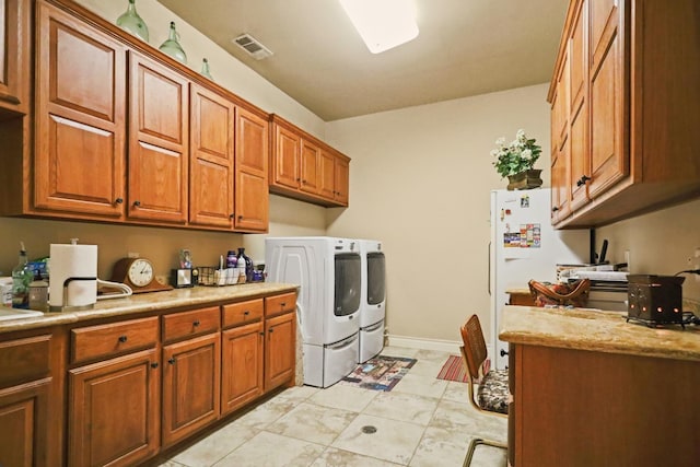 clothes washing area featuring cabinets and independent washer and dryer