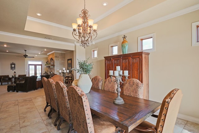 dining area featuring crown molding, light tile patterned flooring, a raised ceiling, and ceiling fan with notable chandelier