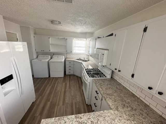 kitchen featuring white appliances, white cabinets, washing machine and clothes dryer, dark hardwood / wood-style flooring, and decorative backsplash