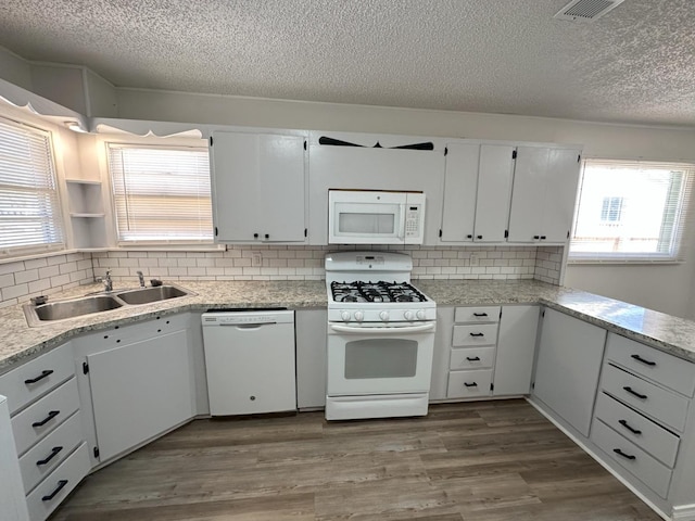 kitchen with white cabinetry, sink, white appliances, and hardwood / wood-style flooring