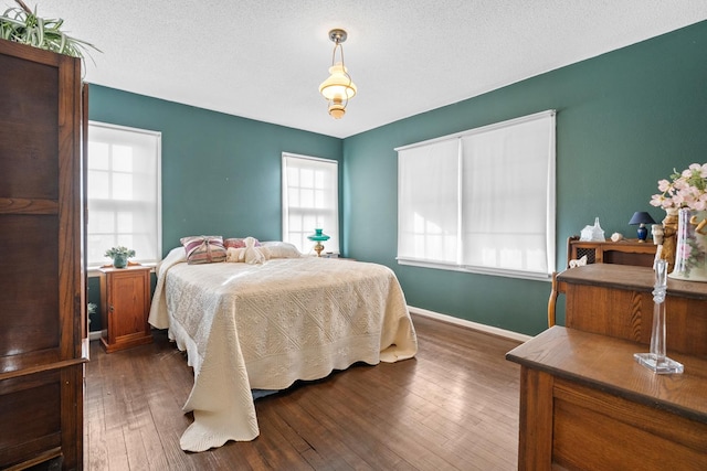 bedroom with dark hardwood / wood-style floors and a textured ceiling