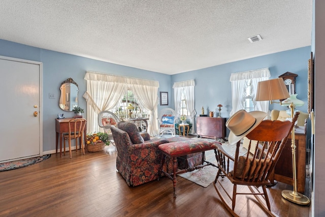 living room featuring a textured ceiling and dark hardwood / wood-style flooring