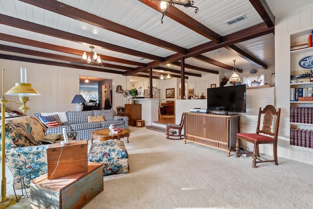 carpeted living room featuring beam ceiling and a notable chandelier