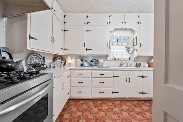 kitchen featuring white cabinetry, stainless steel range oven, sink, and tasteful backsplash