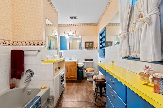 bathroom featuring vanity, wood-type flooring, tile walls, and toilet