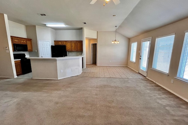 kitchen featuring decorative light fixtures, vaulted ceiling, light carpet, a kitchen island, and black appliances