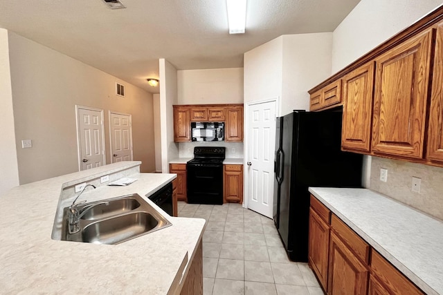 kitchen with sink, backsplash, black appliances, and light tile patterned floors