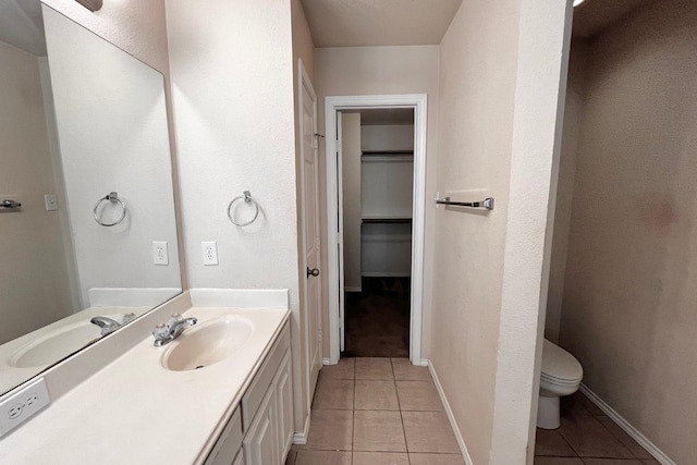 bathroom featuring vanity, tile patterned floors, and toilet