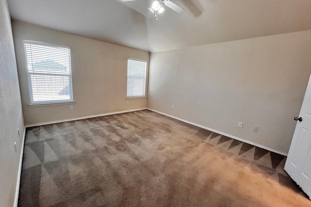 unfurnished room with lofted ceiling, a wealth of natural light, ceiling fan, and carpet flooring