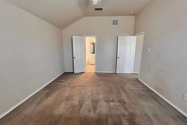 unfurnished bedroom featuring ensuite bathroom, vaulted ceiling, and carpet