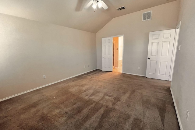 unfurnished bedroom featuring lofted ceiling, dark carpet, ensuite bath, and ceiling fan