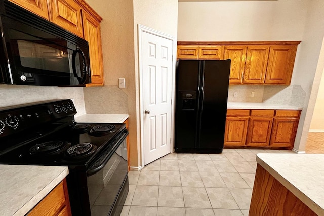 kitchen featuring decorative backsplash, black appliances, and light tile patterned flooring