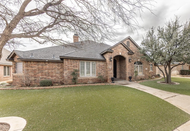 3909 101st St, Lubbock, TX 79423 - view of front of property with brick siding, a front lawn, roof with shingles, and a chimney