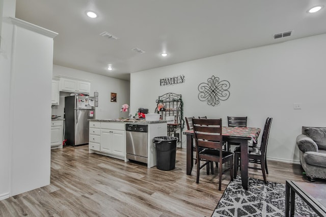 kitchen with stainless steel appliances, light wood-type flooring, and white cabinets