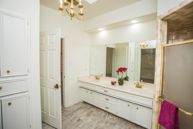 bathroom with an enclosed shower, vanity, and an inviting chandelier