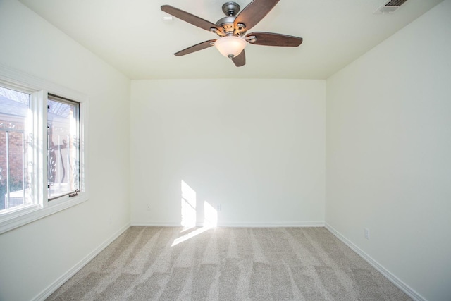 spare room with light colored carpet and ceiling fan